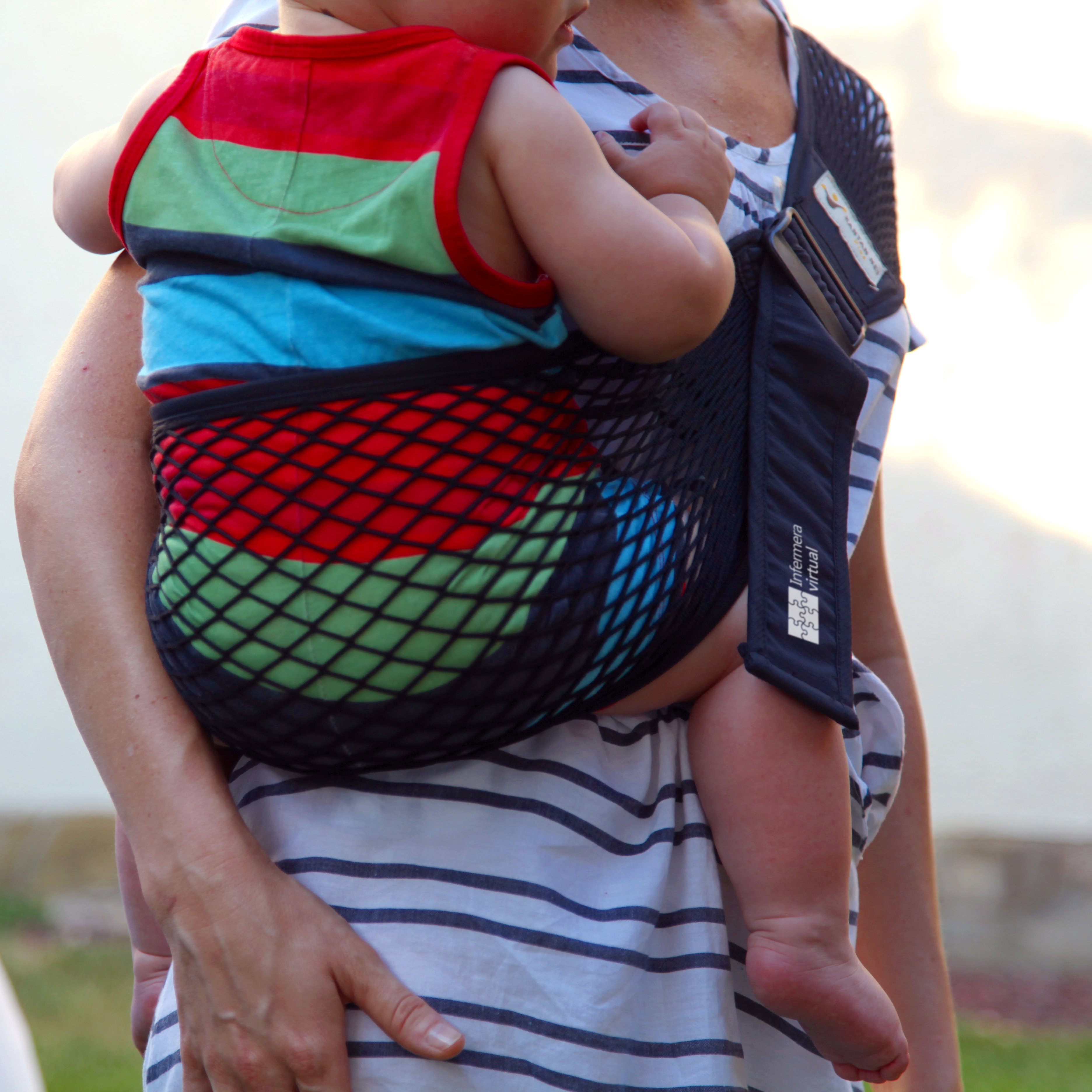 Niño trasportado en un pañuelo portabebés